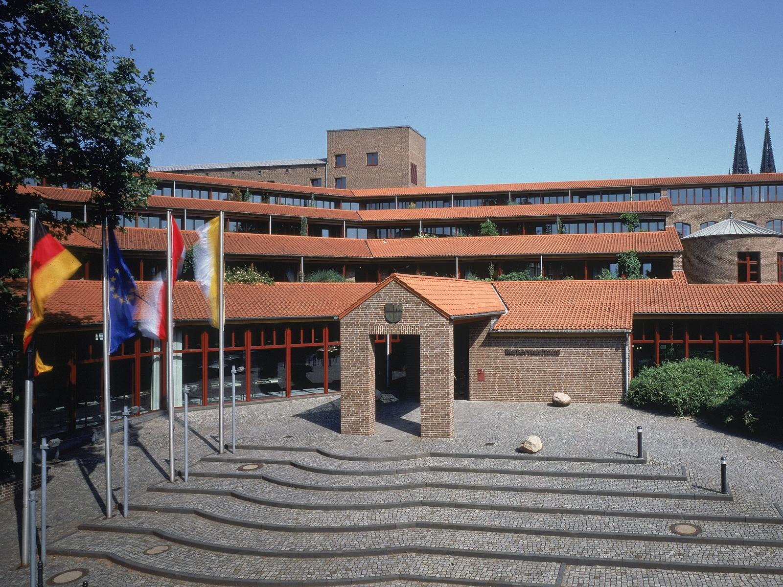 Frontalansicht des Haupteingangs  mit Treppenaufgang bei wolkenlosem Himmel des Maternushaus in der Kölner Innenstadt
