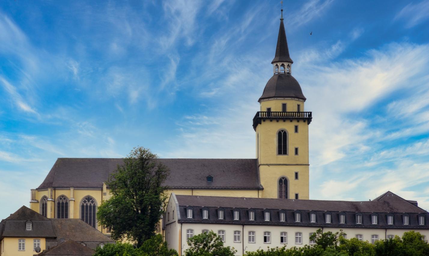 Ansicht auf St. Michael auf dem Michaelsberg in Siegburg, mit dem Restaurant 'Anno17' in der linken unteren Bildecke, sowie dem Gebäude des Katholisch-Sozialen Instituts in der rechten unteren Bildecke.