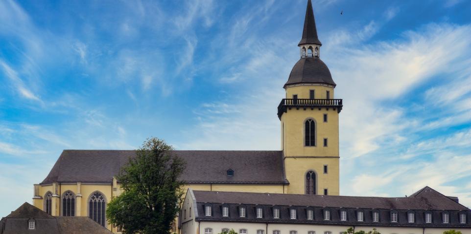 Ansicht auf St. Michael auf dem Michaelsberg in Siegburg, mit dem Restaurant 'Anno17' in der linken unteren Bildecke, sowie dem Gebäude des Katholisch-Sozialen Instituts in der rechten unteren Bildecke.
