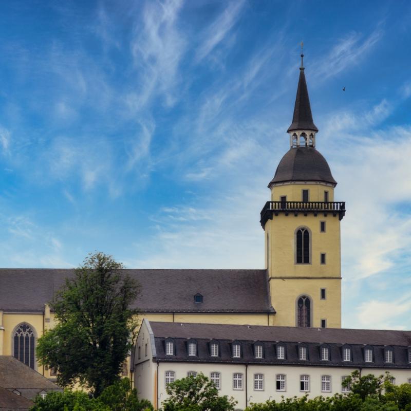 Ansicht auf St. Michael auf dem Michaelsberg in Siegburg, mit dem Restaurant 'Anno17' in der linken unteren Bildecke, sowie dem Gebäude des Katholisch-Sozialen Instituts in der rechten unteren Bildecke.
