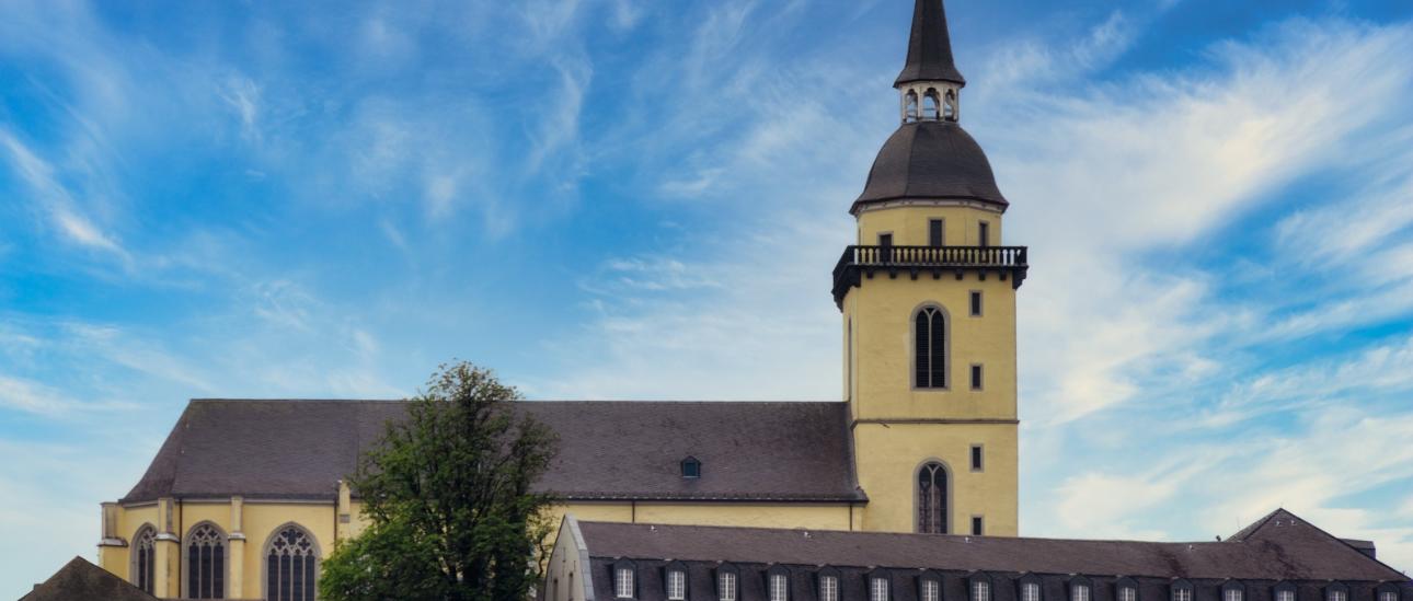 Ansicht auf St. Michael auf dem Michaelsberg in Siegburg, mit dem Restaurant 'Anno17' in der linken unteren Bildecke, sowie dem Gebäude des Katholisch-Sozialen Instituts in der rechten unteren Bildecke.